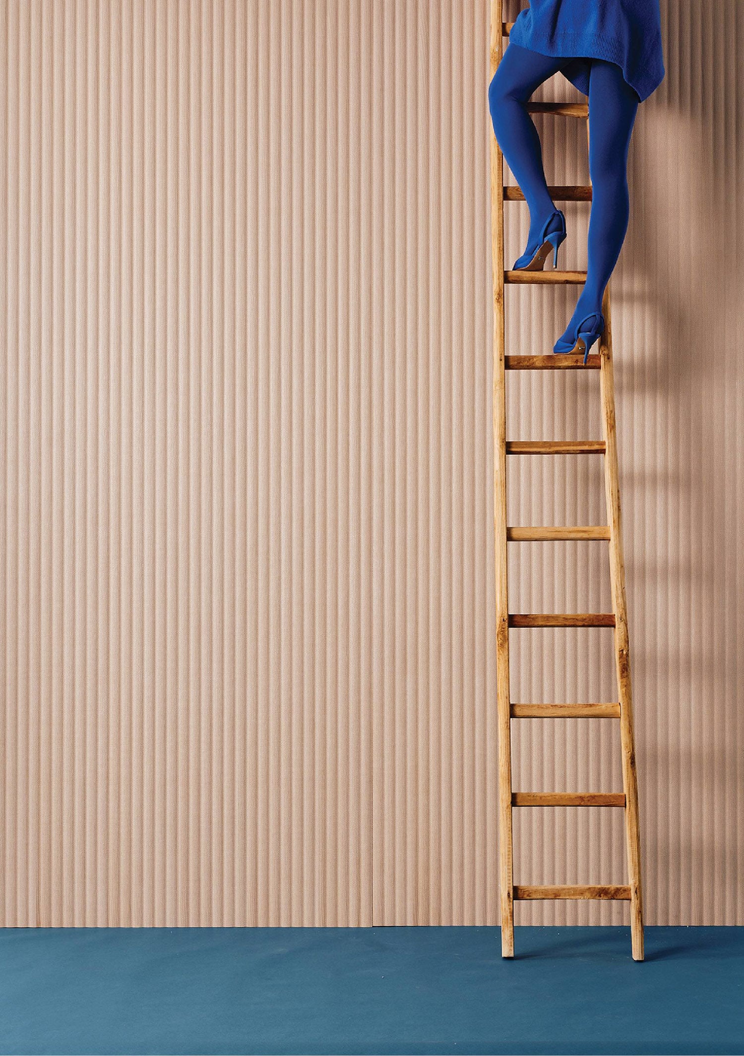 A woman in blue is climbing up a ladder.