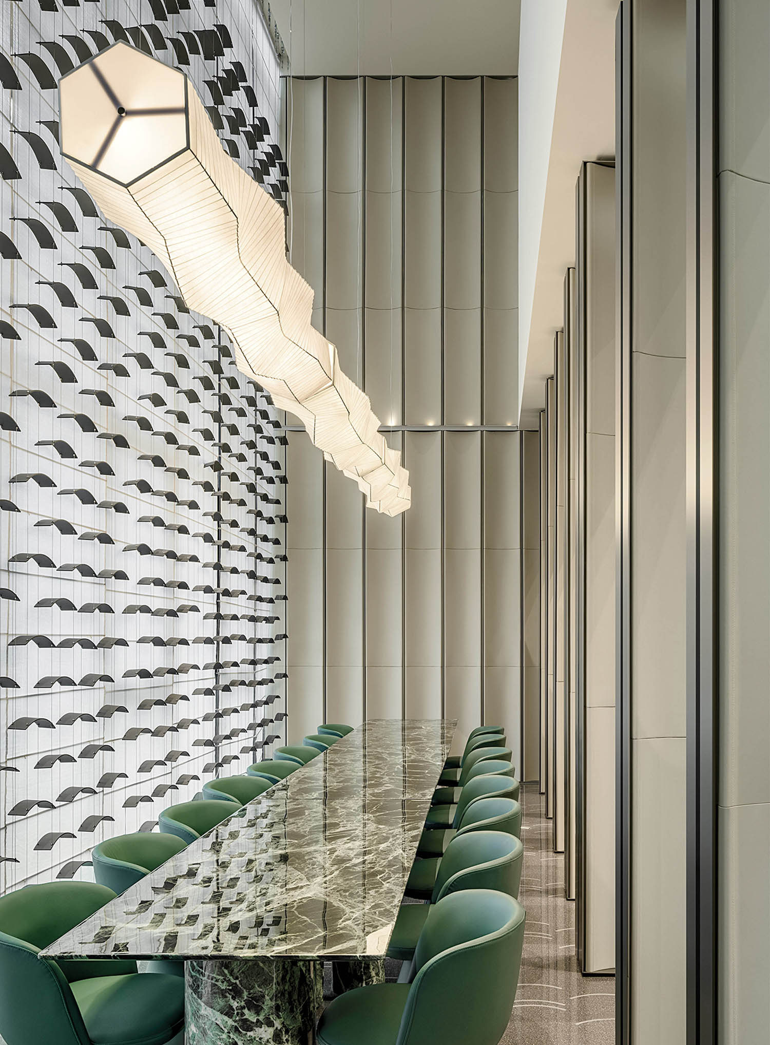 A long table with green chairs and a large mirror.
