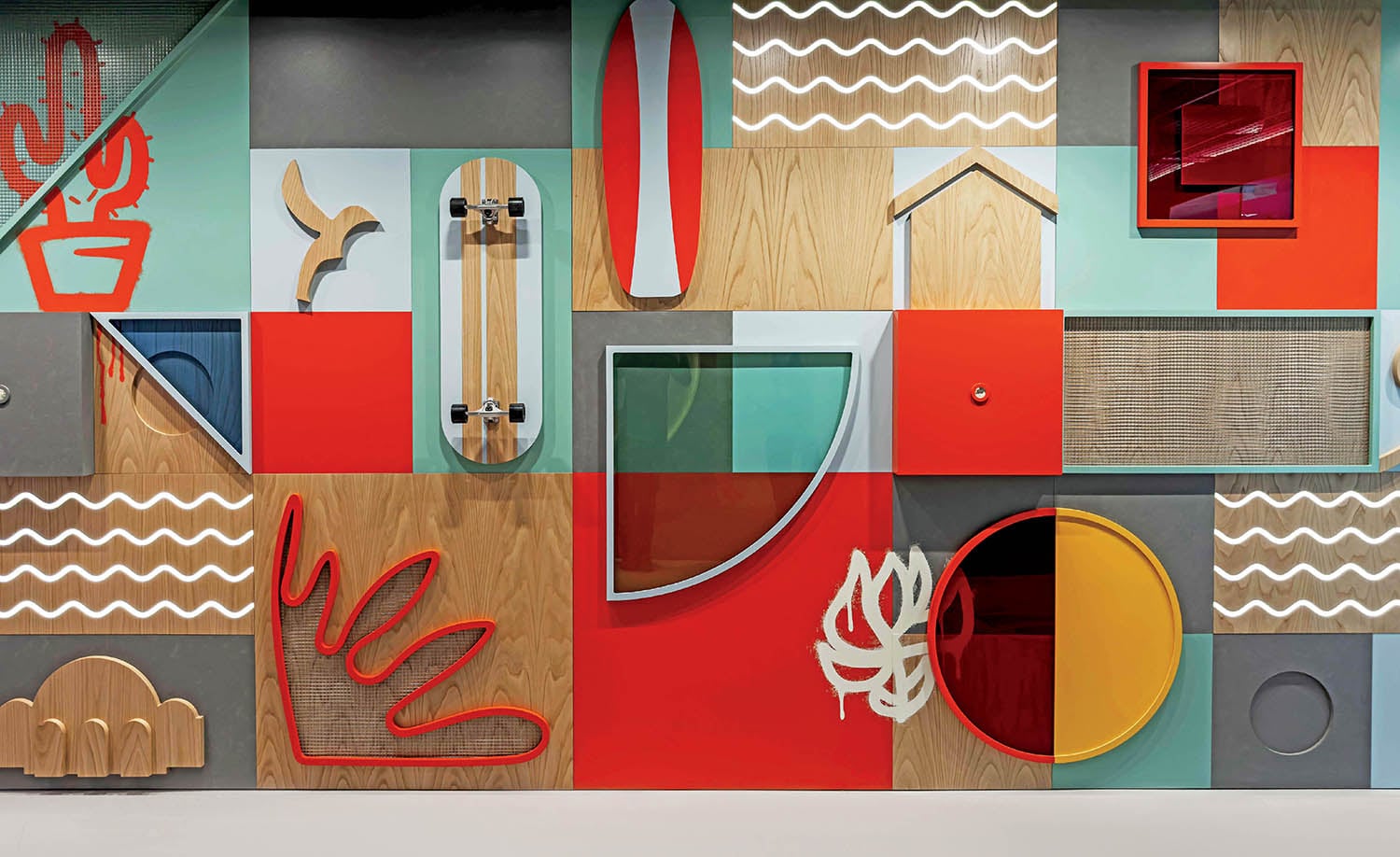 A colorful wall with various objects and a wooden floor.