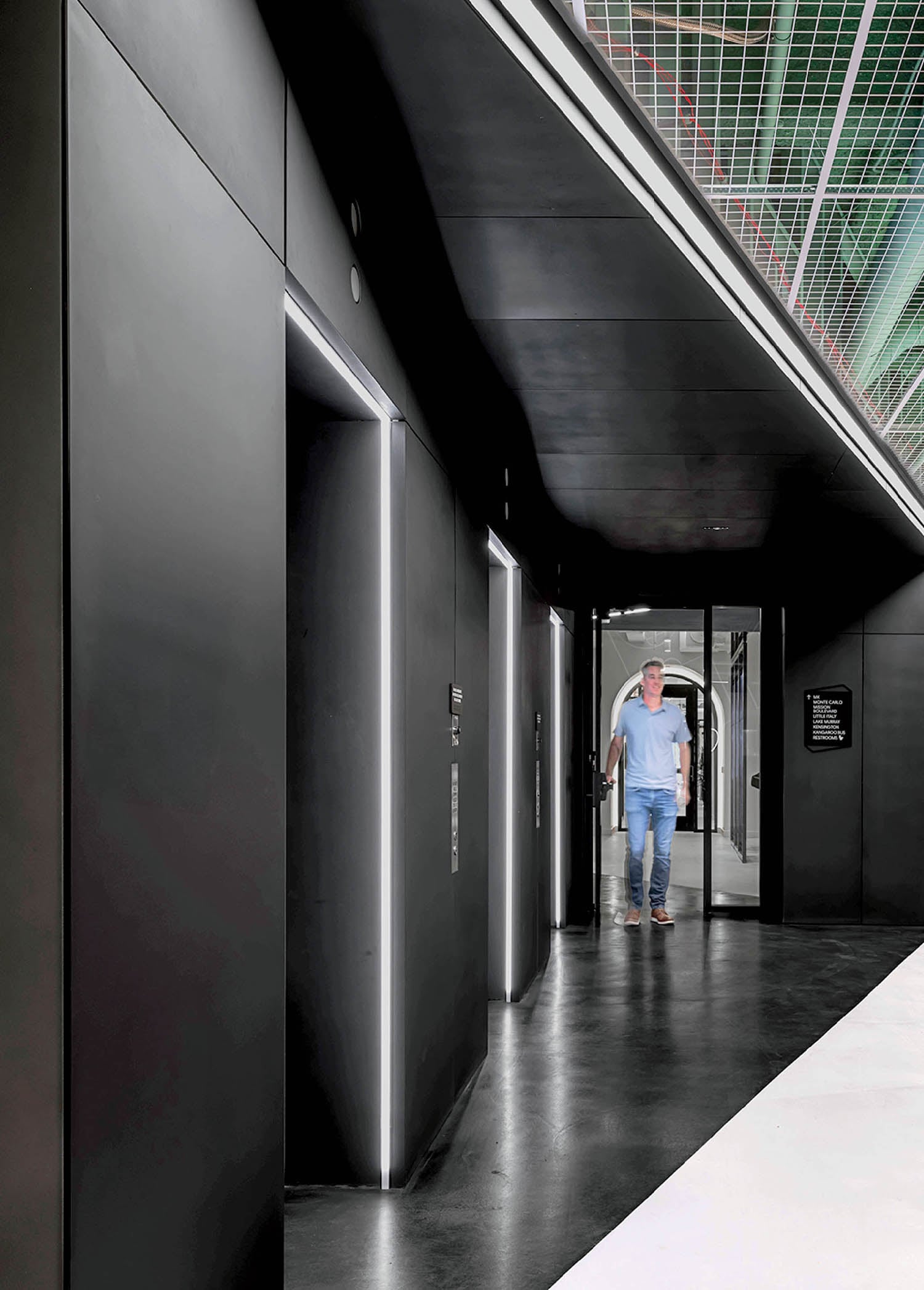 A man walking down a long hallway.