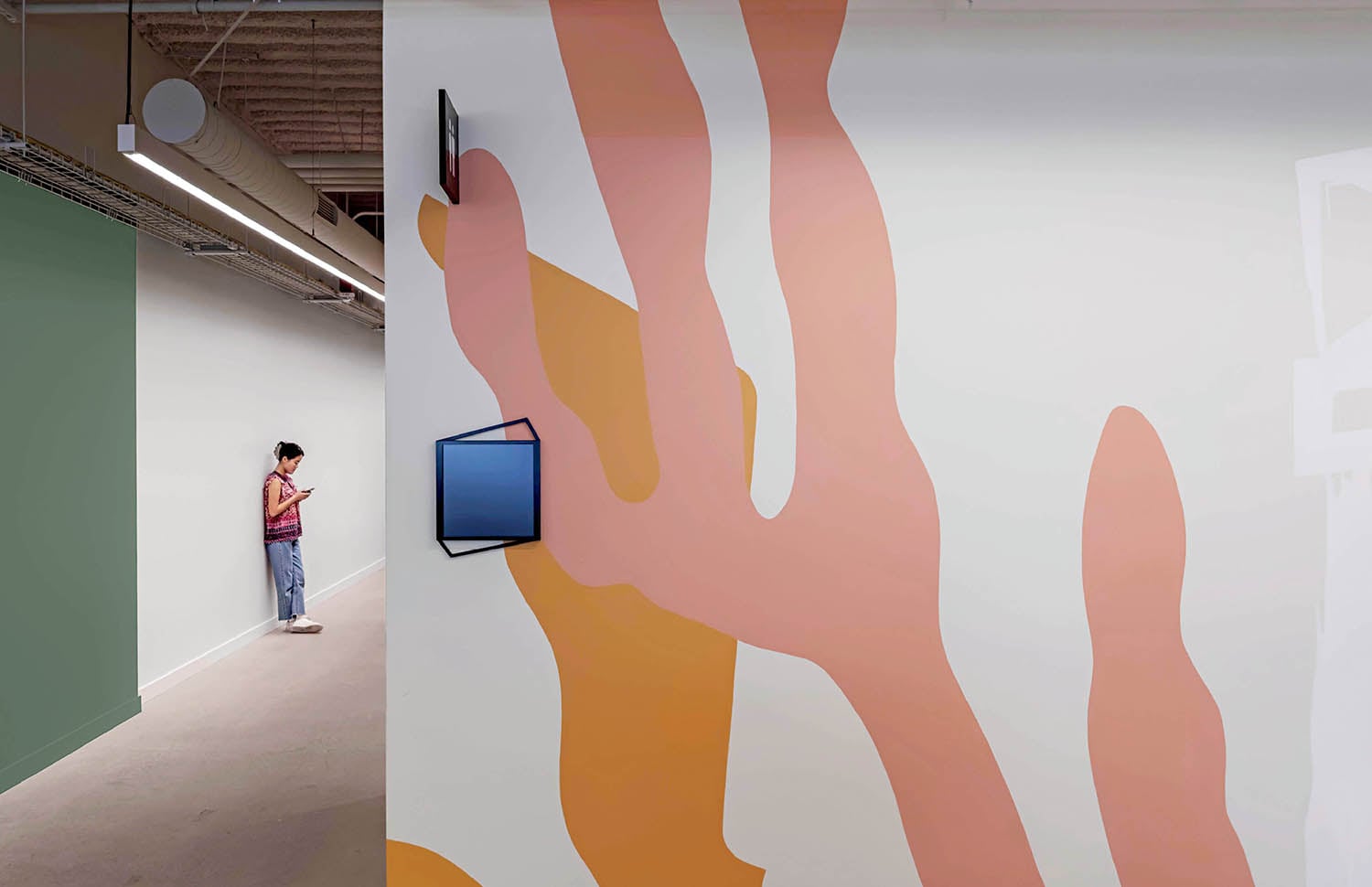 A woman standing in a room with a painting on the wall.