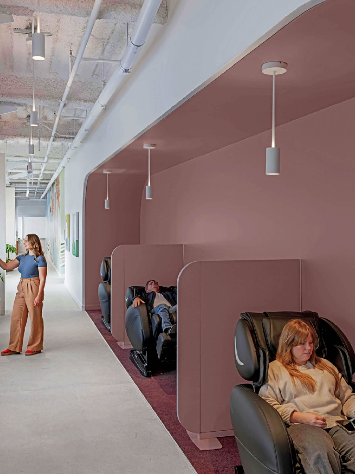 A woman sitting in a massage chair in a room