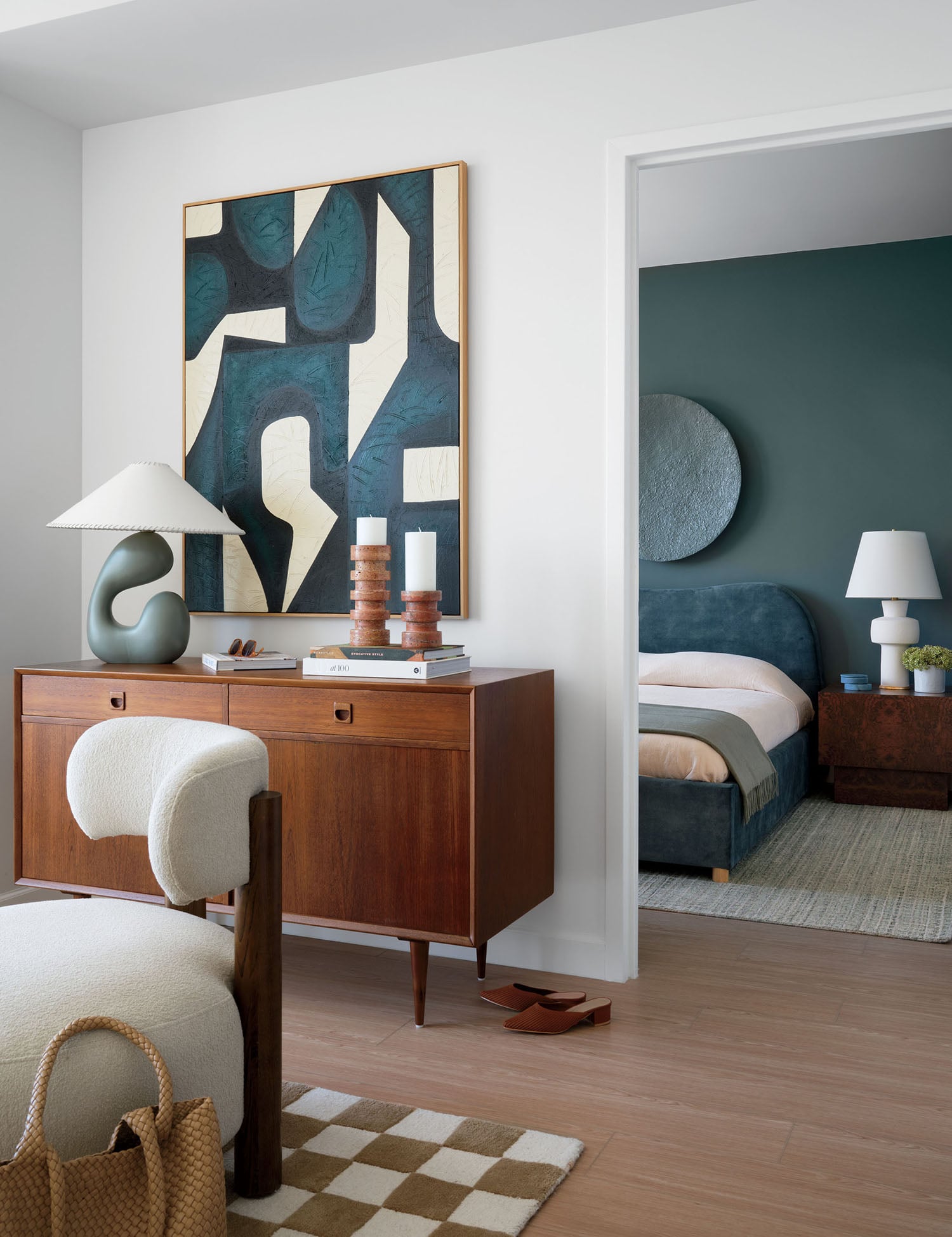 A bedroom with a bed, a chair, and a painting.