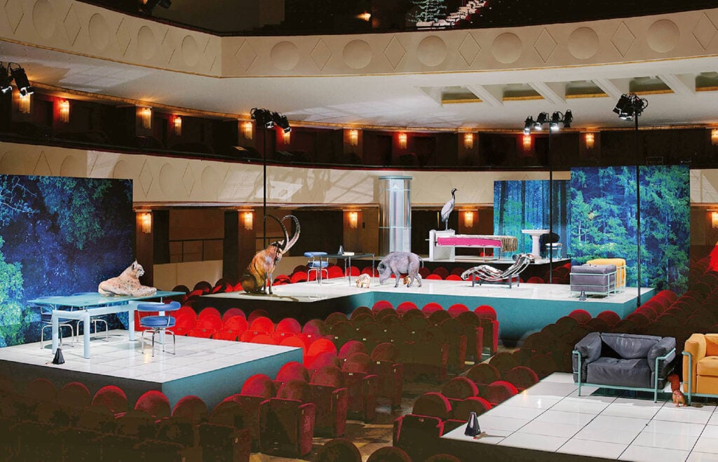 A large room with a large screen and chairs.