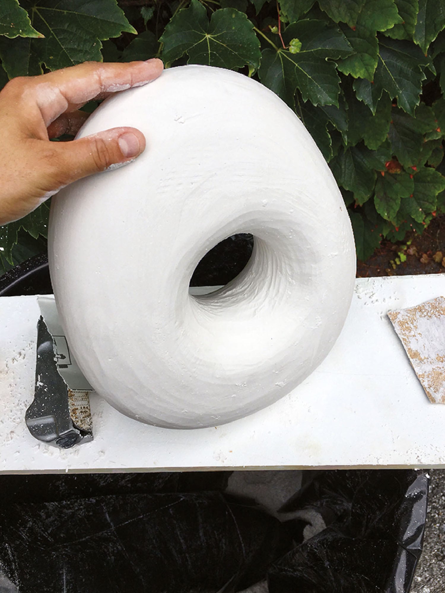 A person is holding a white object in their hand.