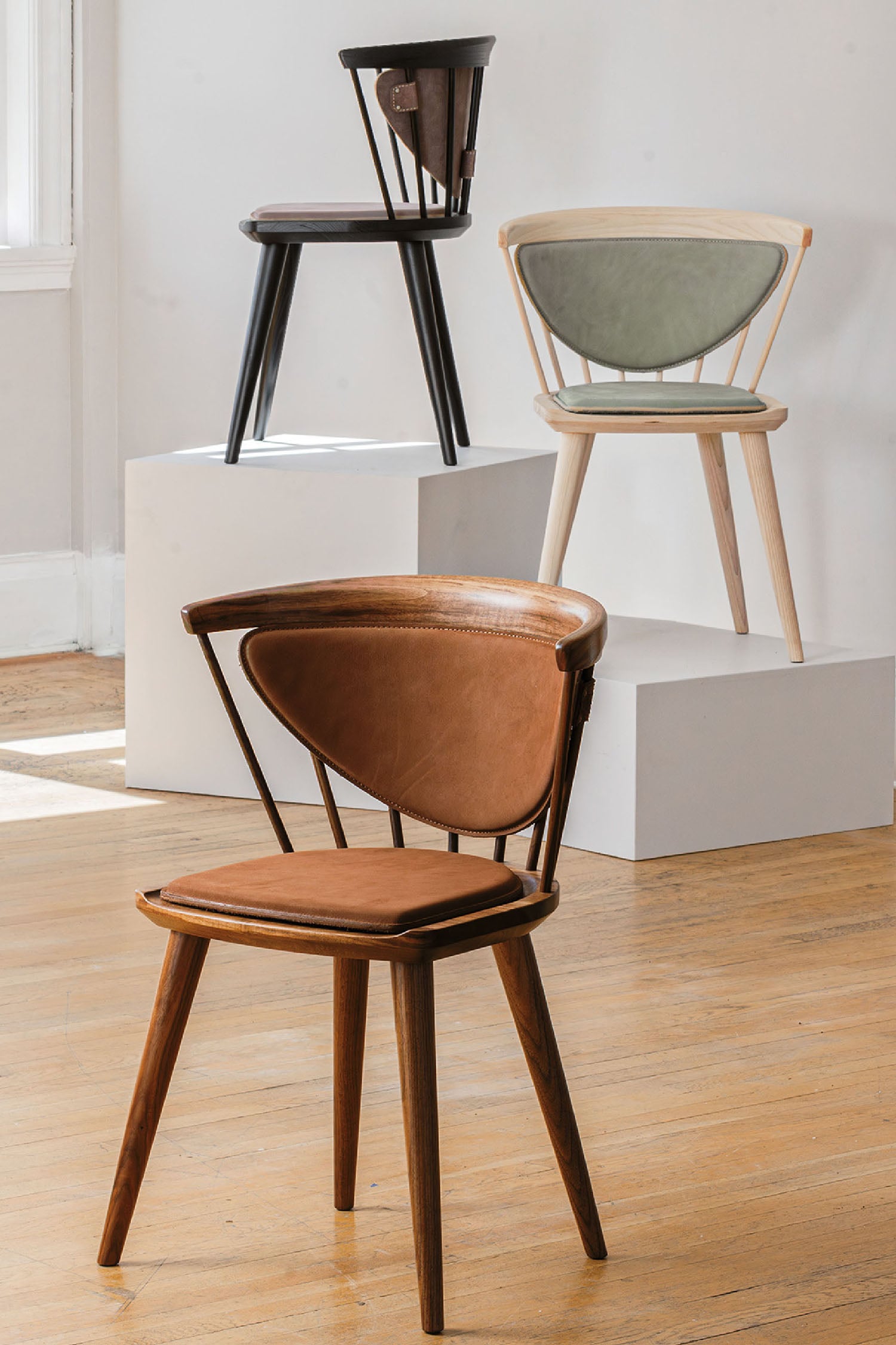 A chair with a wooden seat and a wooden chair with a leather sea.