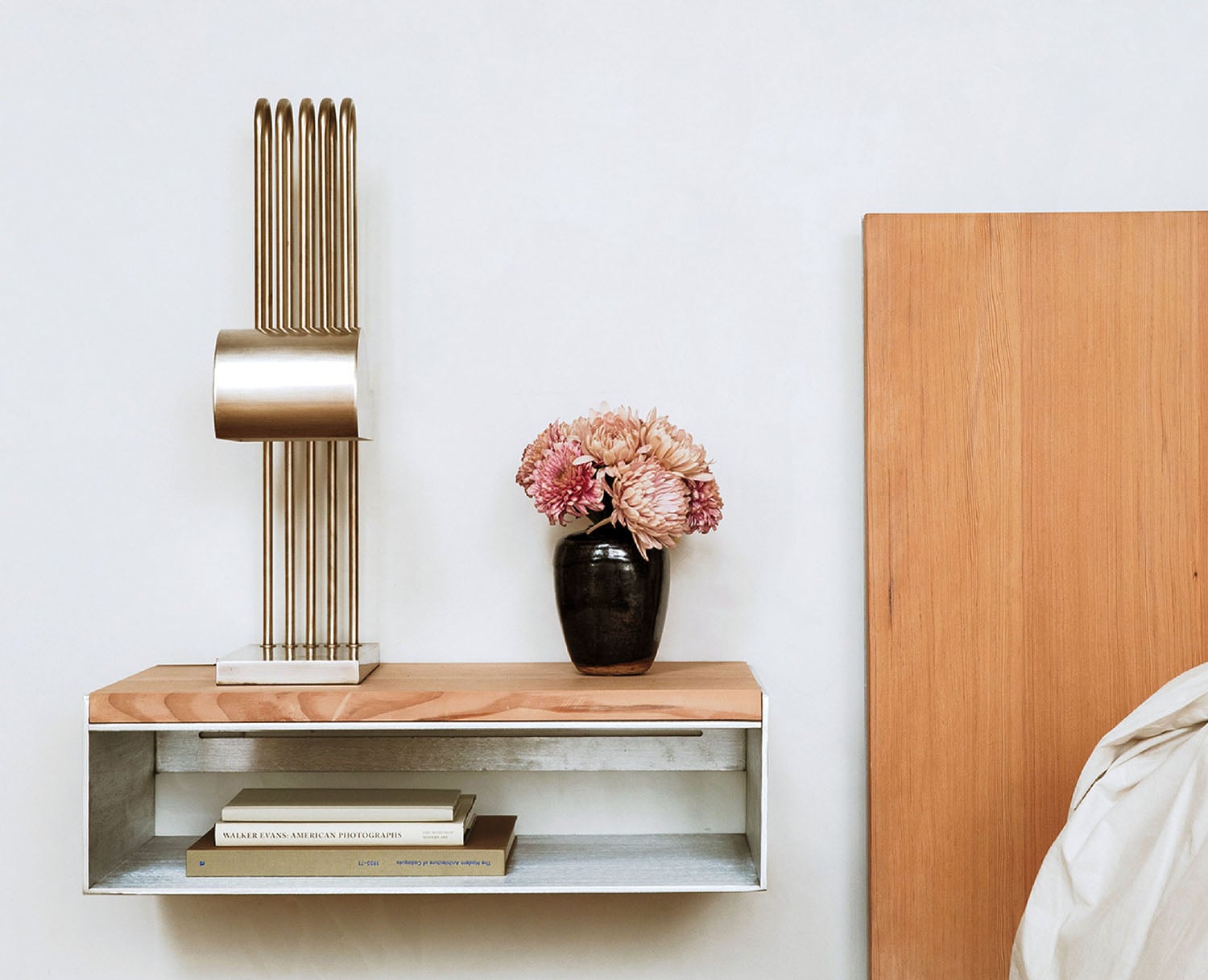 A bed with a vase of flowers on top of it.