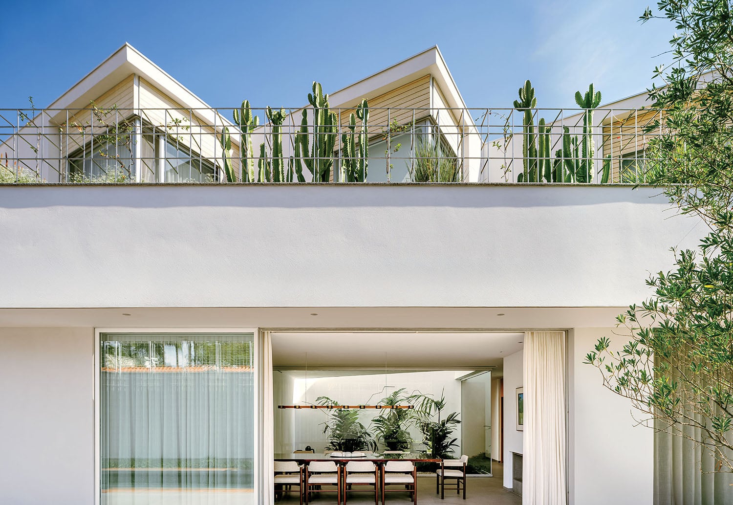 A white house with a balcony and a table.