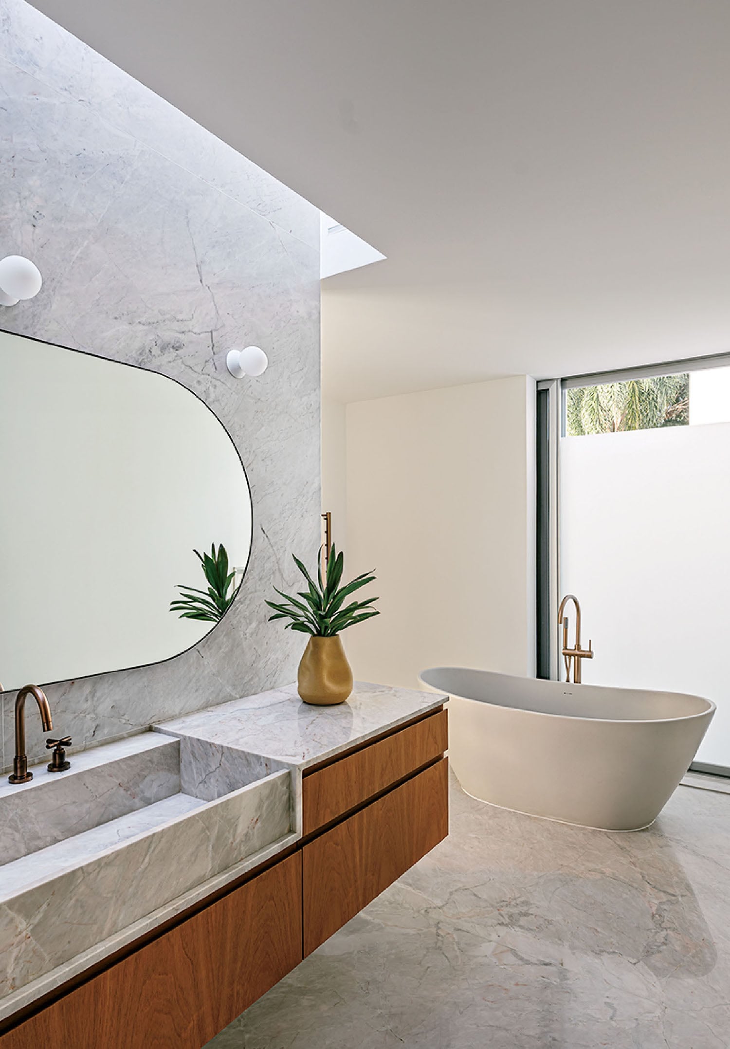 A bathroom with a large mirror and a bathtub.