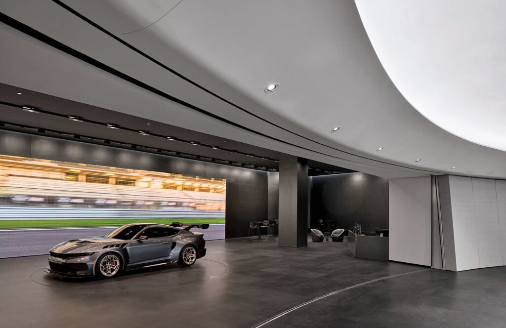 A car is parked inside of a large room.