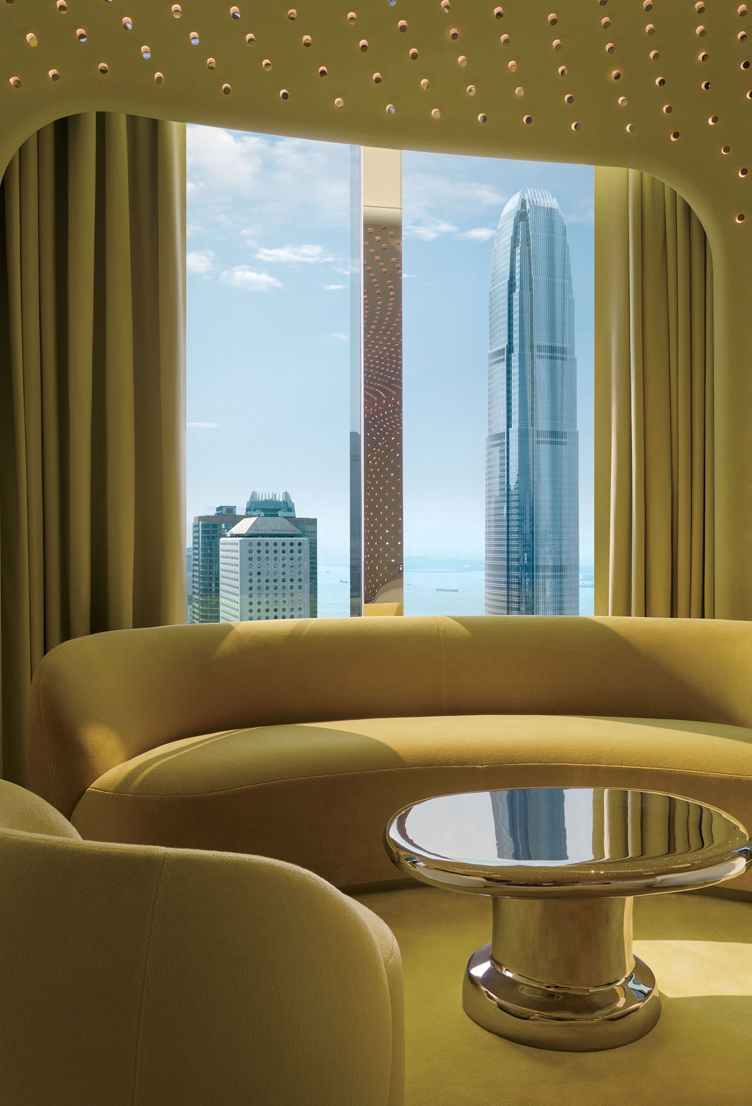 A living room with a round couch and a table.