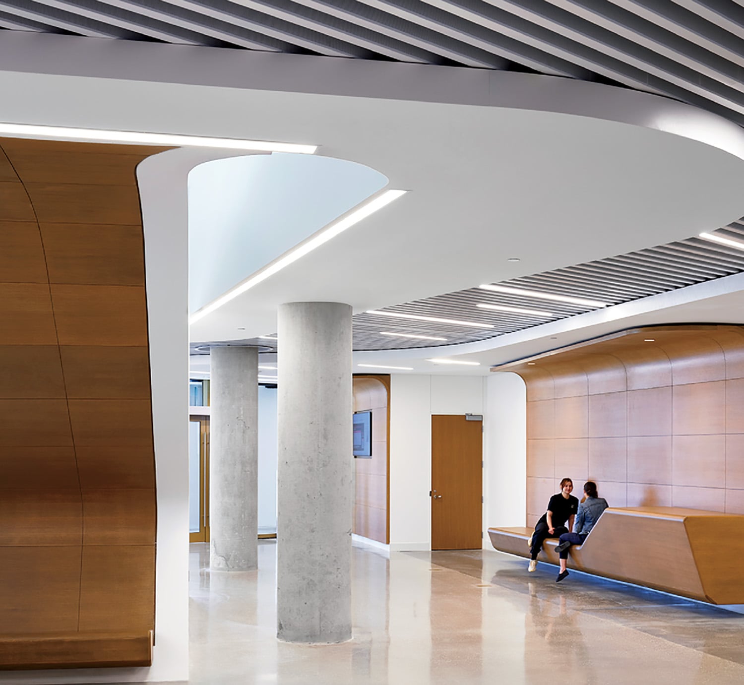 A man sitting on a bench in a large room.
