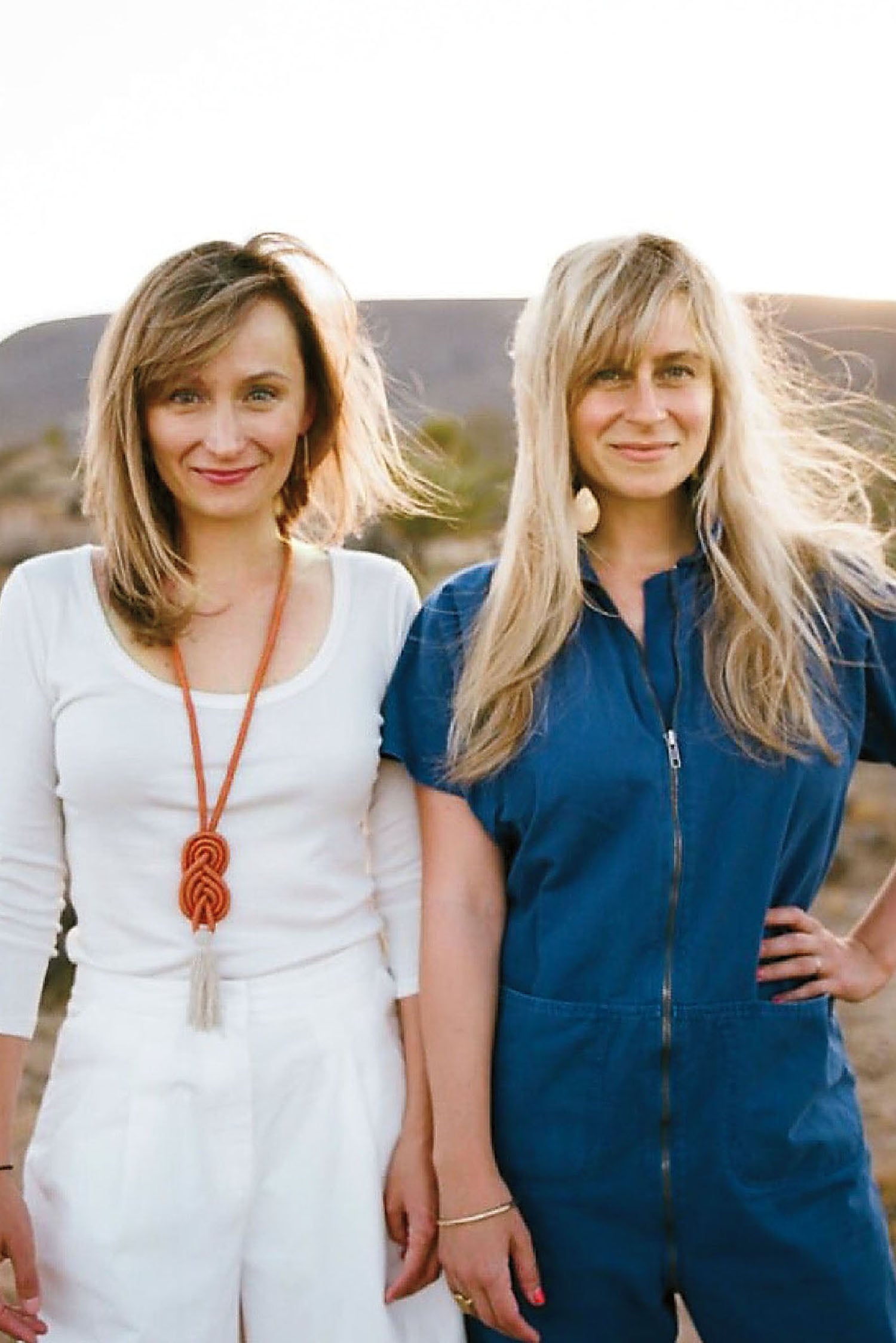 Two women standing in the desert.