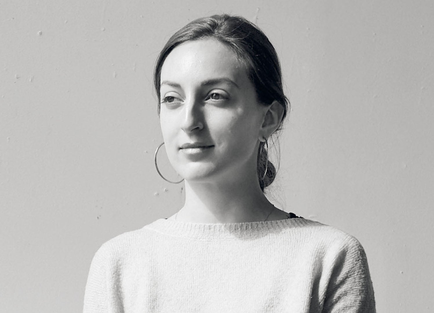 A woman in a white sweater and black pants.