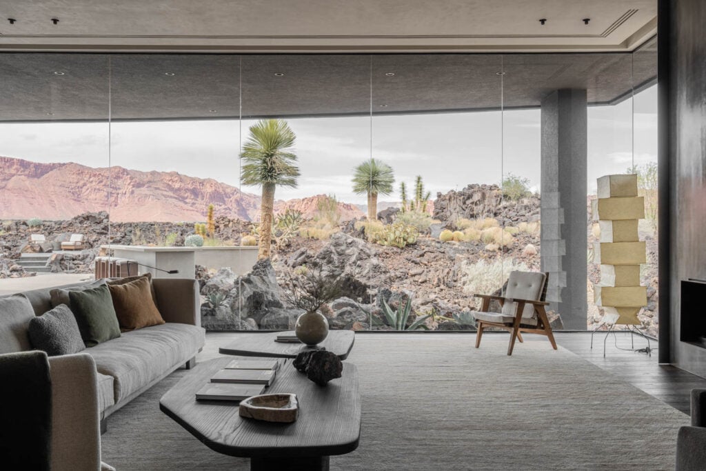 a living room with glass wall overlooking desert scape