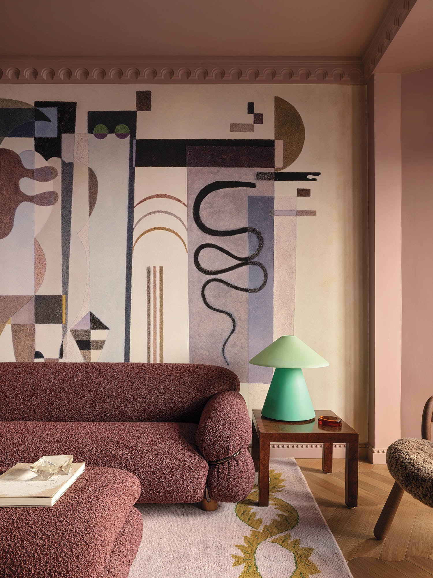 living room with dark red chair, green lamp and art on wall