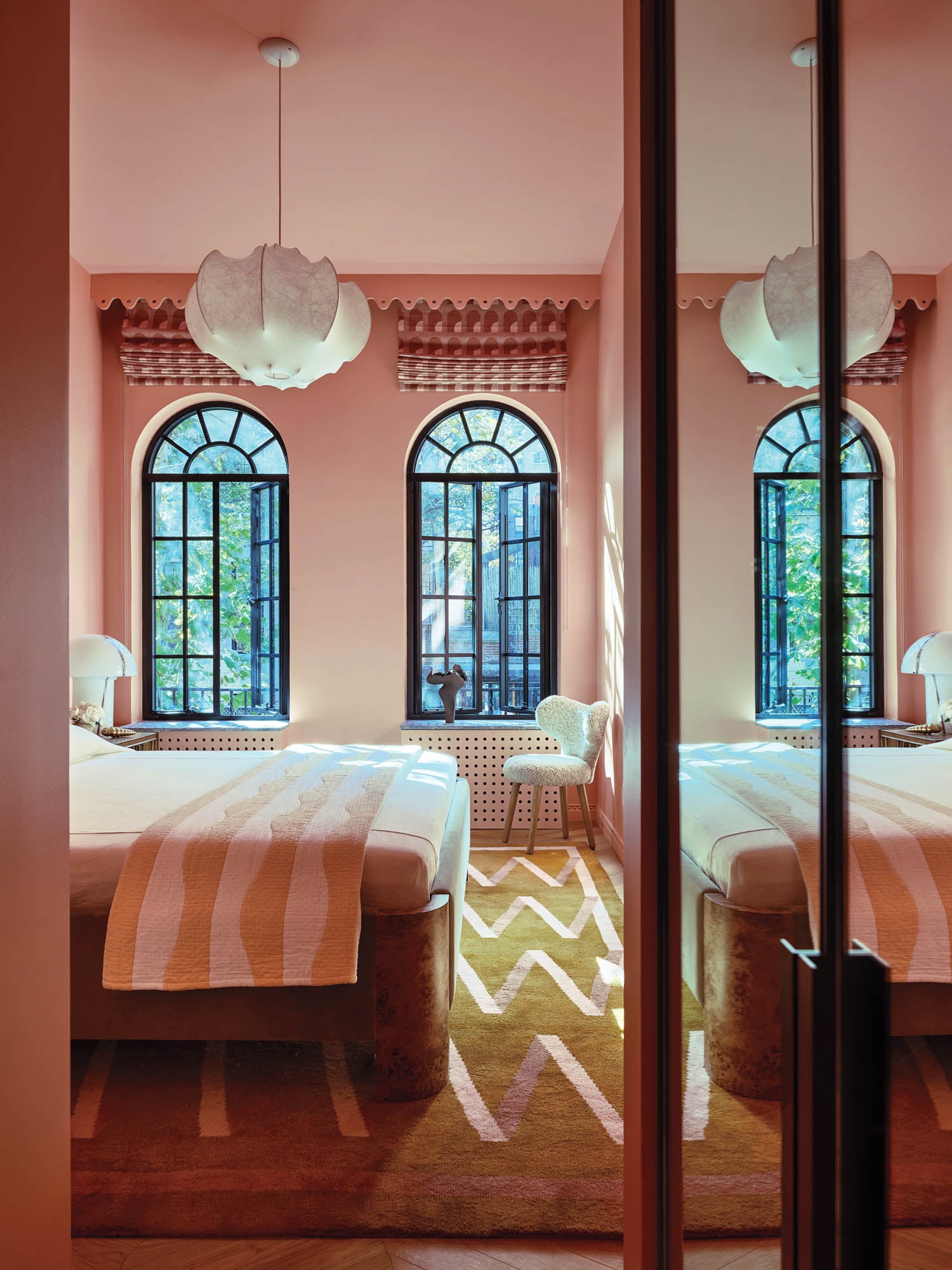 guest room with pale pink walls and yellow rugs with patterns