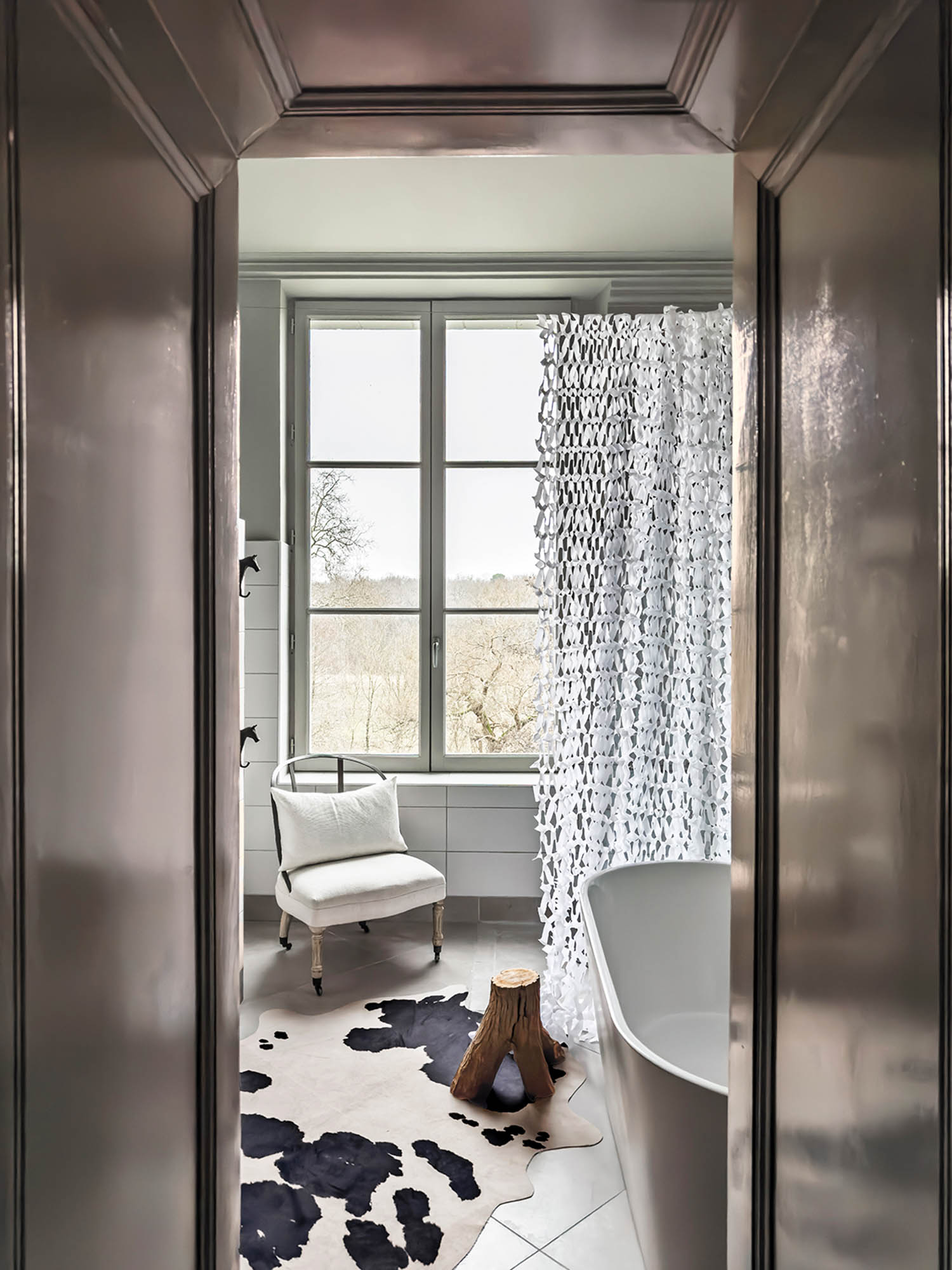 bathroom with curtain, patterned rug and white chair